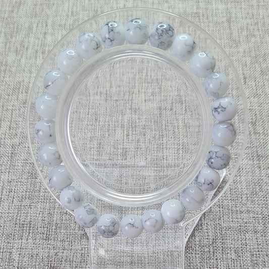 Bracelet en perles blanches marbré:Élégance intemporelle et douceur au quotidien.